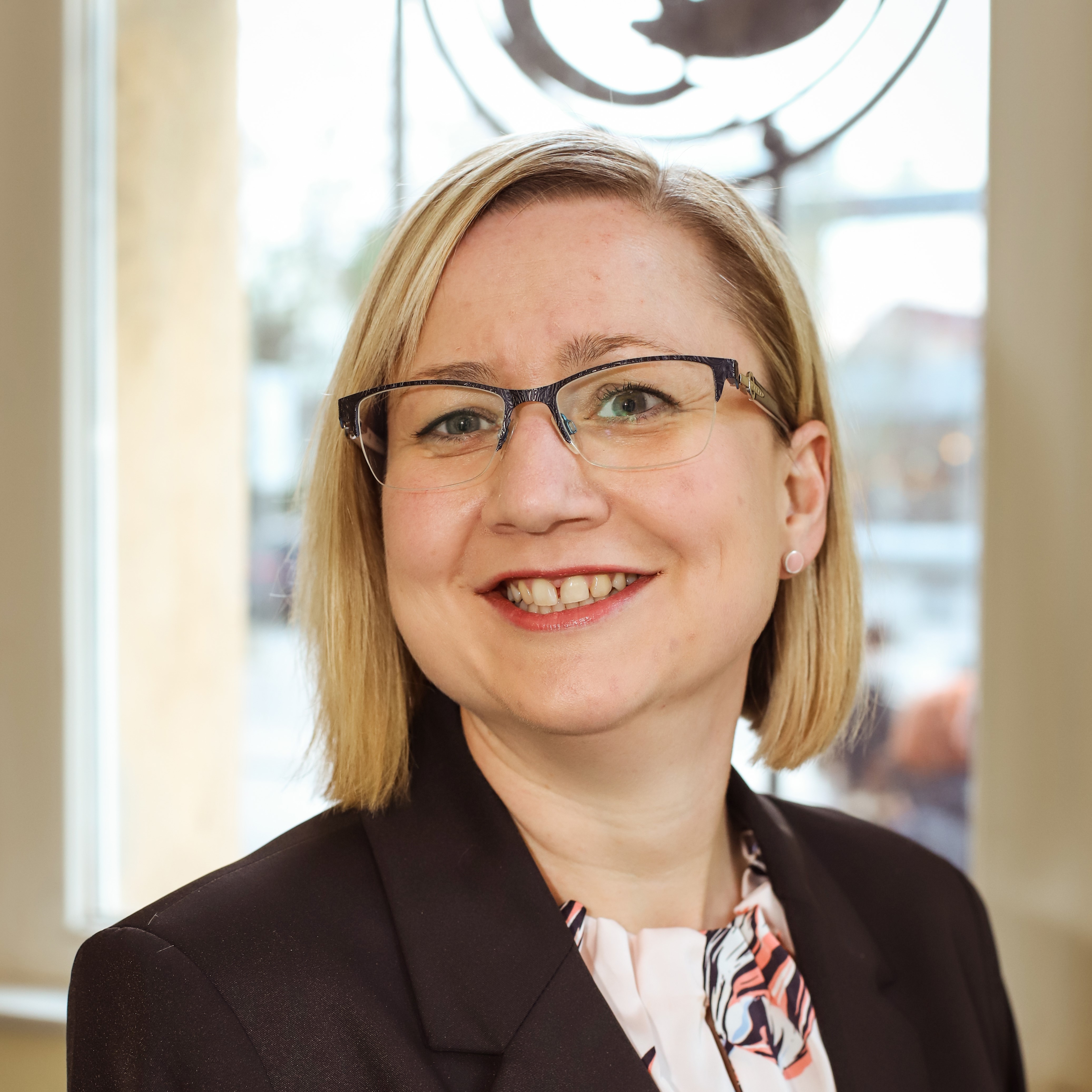 Photo of the business administration manager of IMAGE Information Systems in front of a window